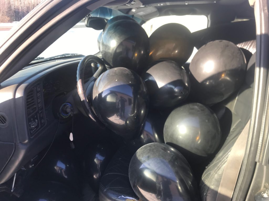 truck full of black balloons